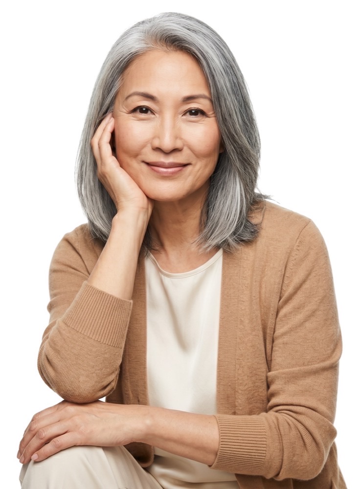 A smiling woman in a camel cardigan