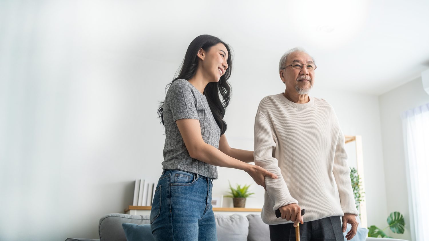 A caregiver helping an older resident walk safely at home